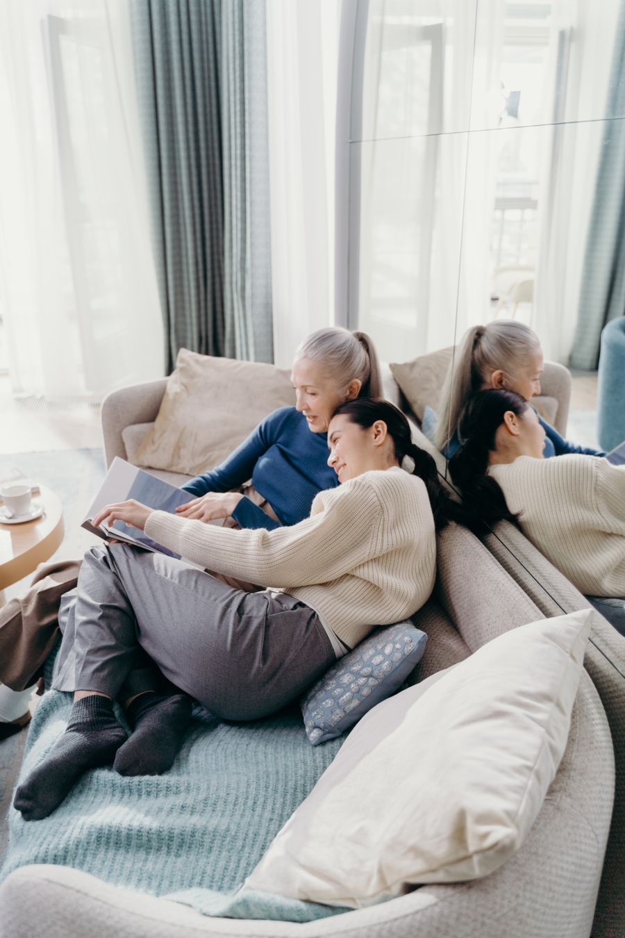 A caregiver and senior relaxing together in a bright living room